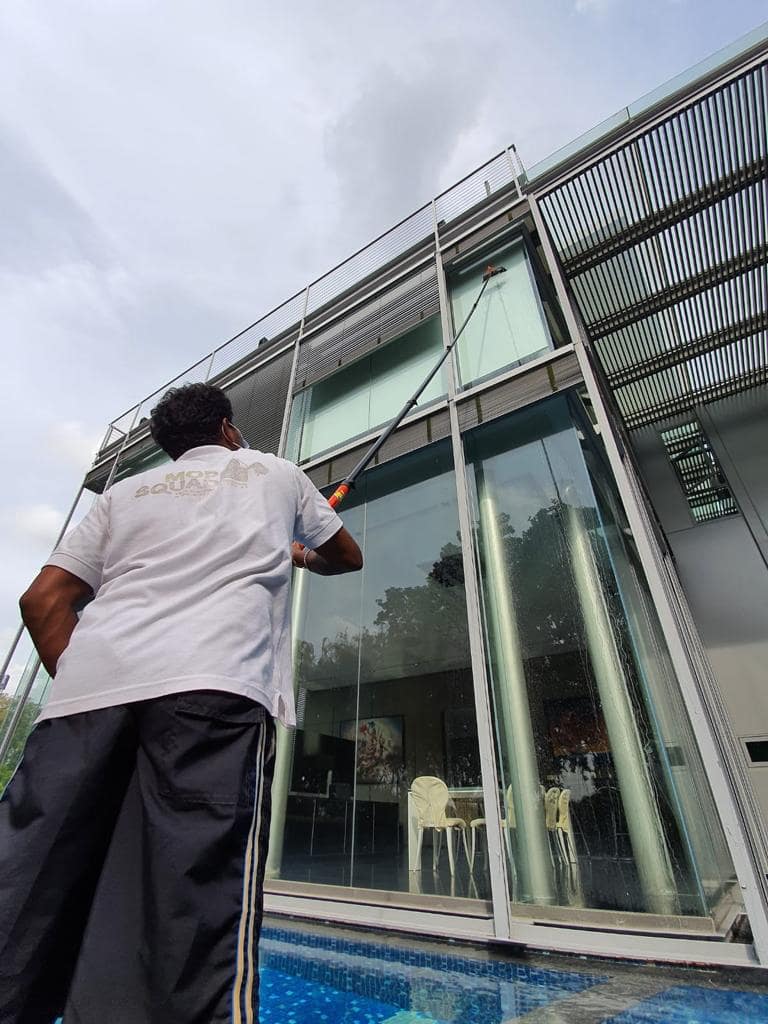 person cleaning window on large building